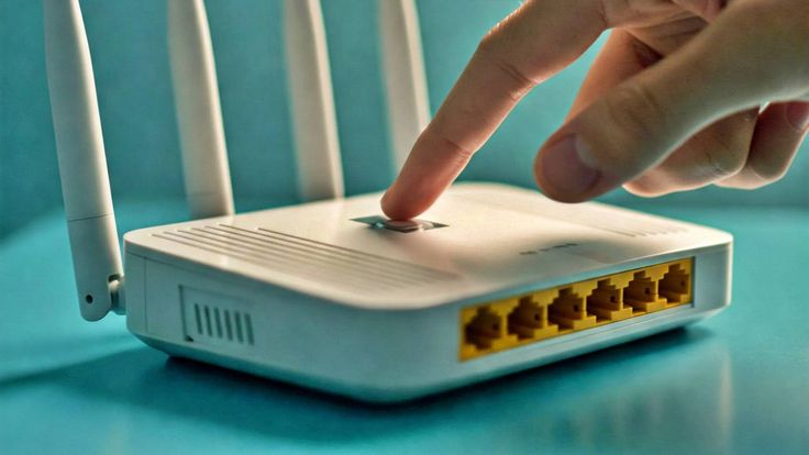 Router WiFi putih dengan kabel LAN, ilustrasi cara update firmware router di rumah